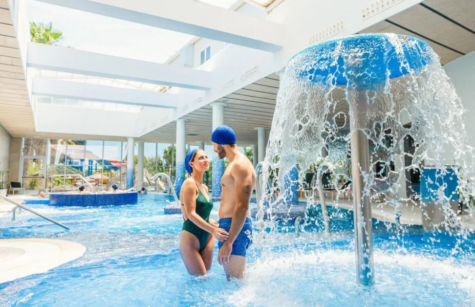 Zona spa con piscina cubierta y cascada de agua en camping