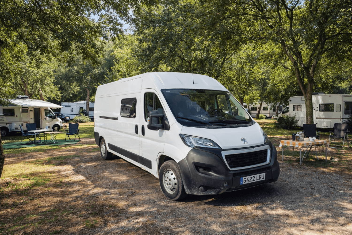 Camper blanca estacionada en camping