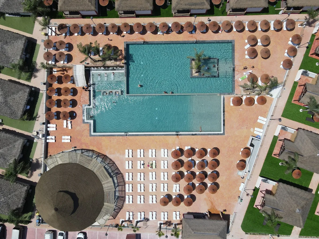 Vista aérea de camping con piscina y zonas de descanso equipada para viajeros en autocaravana