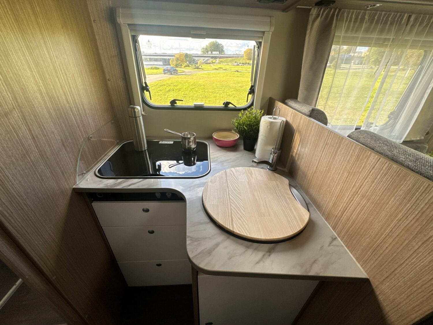 Zona de cocina en autocaravana premium con encimera amplia y almacenaje